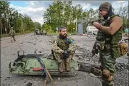  ?? EVGENIY MALOLETKA/AP PHOTO ?? Ukrainian servicemen smoke a cigarettes Monday in the recently recaptured town of Lyman, Ukraine.