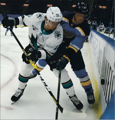  ?? PHOTOS BY JEFF ROBERSON — THE ASSOCIATED PRESS ?? The Sharks’ Nikolai Knyzhov, left, and the St. Louis Blues’ Jaden Schwartz chase after a loose puck along the boards.