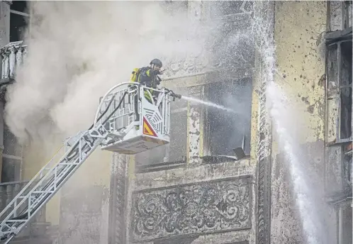  ?? ?? A firefighte­r gestures while spraying water inside a building at the site of a Russian missile attack on the Ukrainian capital Kyiv