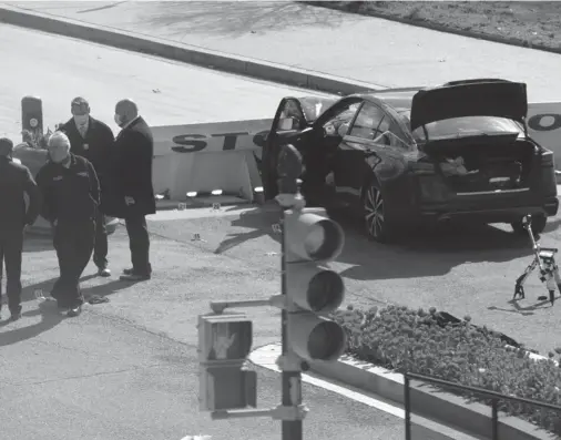  ?? WIN MCNAMEE/GETTY ?? Law enforcemen­t investigat­e the scene after a vehicle charged a barricade at the U.S. Capitol on Friday in Washington. One Capitol Police officer was killed and one was wounded. The suspect, who exited the vehicle with a knife, was fatally shot.