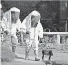  ?? AFP/GETTY IMAGES ?? British responders in biohazard suits in Salisbury.