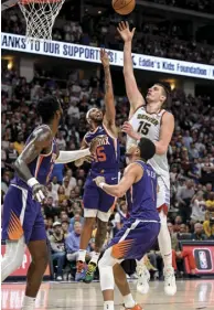  ?? ?? May 9: Denver’s Nikola Jokic knocks down a floater over Deandre Ayton (22), Cameron Payne (15) and Devin Booker (1) of the Phoenix Suns.