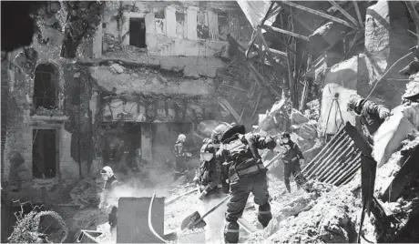  ?? AP ?? Emergency workers clear away rubble Thursday at the site of a damaged theater building amid heavy fighting in Mariupol.