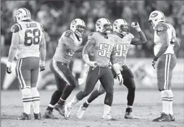  ?? The Associated Press ?? Titans linebacker Zach Brown (55) celebrates with Derrick Morgan (91) and Kamerion Wimbley (95) after Brown recovered a fumble by Jets quarterbac­k Mark Sanchez with 43 seconds left in the fourth quarter Monday. The Titans won 14-10.