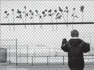  ?? A BOY Eric Gay Associated Press ?? looks through a fence at the Littleton, Colo., school, where 13 were killed on April 20, 1999.