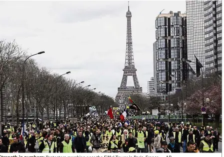  ?? — AP ?? Strength in numbers: Protesters marching near the Eiffel Tower in Paris, France.