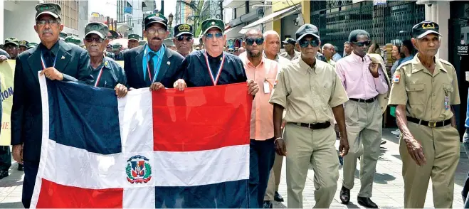  ??  ?? Militares constituci­onalistas caminaron por la calle El Conde tras celebrar una misa en la Catedral Primada de América en memoria de los caídos en la batalla del 15 y 16 de junio de 1965.