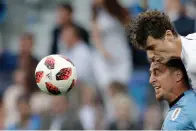  ?? Associated Press ?? ■ France's Benjamin Pavard, top, and Uruguay's Cristian Rodriguez challenge for the ball Friday during the quarterfin­al match between Uruguay and France at the 2018 World Cup in the Nizhny Novgorod Stadium in Nizhny Novgorod, Russia.