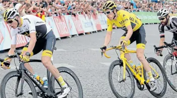  ?? Picture: GETTY IMAGES / MUSTAFA YALCIN ?? PRESSURE: Geraint Thomas of Great Britain, centre, competes with teammate Chris Froome of Great Britain, left, on the Champs-Elysees avenue before winning the Tour de France in Paris in 2018.