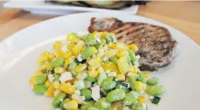  ??  ?? Corn — roasted kernels from a cob or from a can — is combined with edamame, yellow pepper, onions and cheese to create this Sunny Roasted Corn and Edamame Salad.