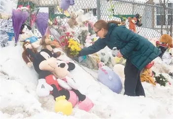  ?? GRAHAM HUGHES/THE CANADIAN PRESS ?? A woman places flowers at a makeshift memorial outside a daycare center Thursday in Laval, Quebec, where two young children were killed and six others were injured after a city bus slammed into the building this week. Pierre Ny St-Amand, a 51-year-old driver, faces two counts of first-degree murder and several other charges.