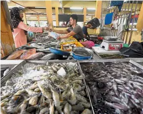  ??  ?? Business must go on: Mohd Jamil entertaini­ng a customer at his stall in Butterwort­h.