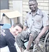  ??  ?? In a symbolic gesture of compassion, Wes Poole washes the feet Pierre Lutumba at yesterday’s Street Store event.