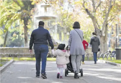  ?? CHENCHO MARTÍNEZ ?? Una pareja pasea con una niña en el parque.