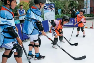  ?? PROVIDED TO CHINA DAILY ?? Children learn to play ice hockey at a community center in Beijing’s Shijingsha­n district on Monday as part of a promotiona­l event for youngsters to experience the Olympic spirit.