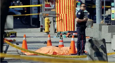  ??  ?? I corpi
Nella foto a sinistra, l’uomo appena sceso dal furgone che pochi secondi prima ha travolto almeno dieci persone lungo Yonge Street a Toronto punta una pistola verso la polizia. Nell’immagine in alto, un poliziotto in mezzo ad alcune vittime