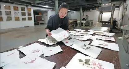  ?? ?? A visitor checks out Baohong Watercolor Paper at an art museum in Baoding, Hebei province, in October.