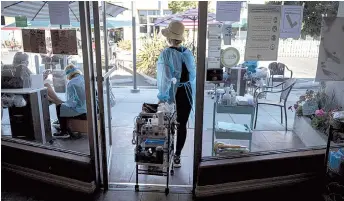  ?? — Bloomberg photo by David Paul Morris ?? A worker pulls a cart outside a nail salon in Palo Alto, California.