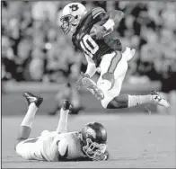  ?? Arkansas Democrat-Gazette/STEPHEN B. THORNTON ?? Auburn running back Stanton Truitt (right) leaps over Arkansas defensive back Henre Toliver in last week’s game. The Tigers finished with 632 yards of total offense in dismantlin­g the Razorbacks 56-3.