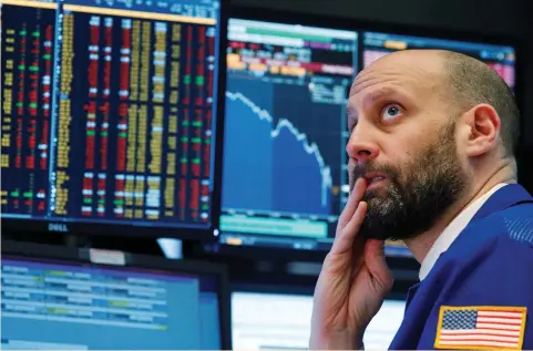  ?? (Brendan McDermid/Reuters) ?? A TRADER watches screens on the floor of the New York Stock Exchange on Monday, when investors rushed into Treasuries as the S&P 500 and Dow Jones Industrial Average nosedived more than 4%.