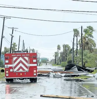  ?? GABE HERNANDEZ/CORPUS CHRISTI CALLER-TIMES VIA AP ?? Port Aransas Fire Department survey the area after Hurricane Harvey landed in the Coast Bend area on Saturday, in Port Aransas, Texas.