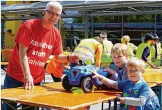  ??  ?? David, 4 Jahre, und sein Bruder Simon, 7, gaben ihr blaues Bobbycar bei Jürgen Mül ler ab, dem Vorsitzend­en der Zeitbörse.