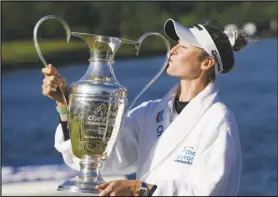  ?? Associated Press ?? Nelly Korda kisses the trophy while posing for photos after winning the Chevron Championsh­ip LPGA golf tournament, Sunday, at The Club at Carlton Woods in The Woodlands, Texas.