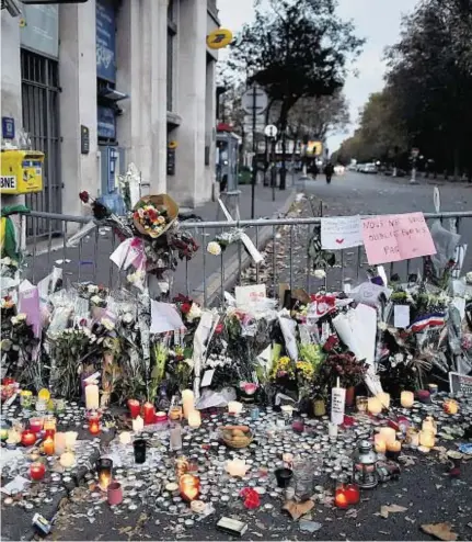  ??  ?? the pavement near the Bataclan Theatre, as Paris stops to remember the victims of the terror attacks