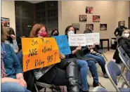  ?? BOB KEELER - MEDIANEWS GROUP ?? As a district police officer, right, looks on, counterpro­testers at Souderton Area School Board’s Jan. 27 meeting hold up signs in response to signs held up at the board’s Finance Committee meeting on Jan. 12. The Jan. 24sign bearers were told it was a mistake that the signs were allowed to remain at the Jan. 12 meeting and that the sign bearers had the option of putting the signs down or leaving the meeting.