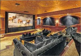  ??  ?? IN ADDITION TO a music room, wine cellar and massive garage space for a car collection, there is a lavish home theater.