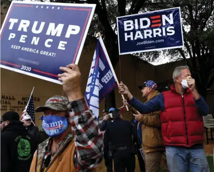  ??  ?? Biden-Harris and Trump-Pence supporters stand together at Vera Minter Park in Abilene, Texas last week. Common ground between two factions of the same nation can feel non-existent. Photograph: Ronald W Erdrich/AP