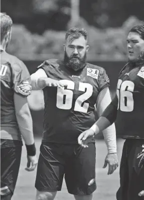  ??  ?? The Eagles’ Jason Kelce (62), Ian Park (66) and Nate Sudfeld talk during training camp on Thursday.