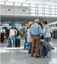 ?? Foto: Peter Kneffel/dpa/Symbolbild ?? Und ab in den Urlaub: Diese Fluggäste waren in München am Flughafen auf den Check-in.
