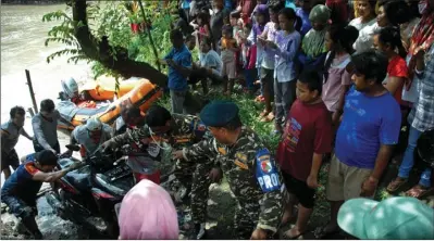  ?? HANUNG HAMBARA/JAWA POS ?? SOSIAL: Banser bersama warga dan petugas mengevakua­si sepeda motor korban perahu tambang yang oleng pada Kamis (13/4).