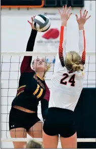  ?? Staff photo/Jason Alig ?? New Bremen’s Mia Schmitmeye­r goes to spike the ball last as Minster’s Lilly Barhorst goes for the block on Thursday.