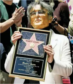  ??  ?? Left: 2002 file photo: Robert Evans poses with a plaque after his star was unveiled on the Hollywood Walk of Fame.