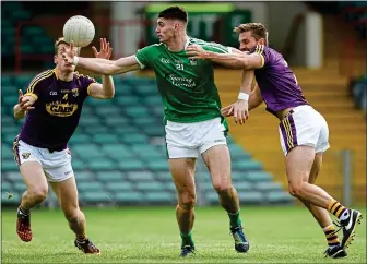  ??  ?? CLOSING IN: Josh Ryan of Limerick attempts to hold off the advances of Wexford pair Jim Rossiter (left) and Brian Malone in yesterday’s AllIreland qualifier at the Gaelic Grounds