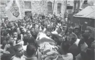  ??  ?? Funéraille­s de Awss Salameh, un Palestinie­n de 17 ans, dont le corps est porté par la foule jusqu’au cimetière et recouvert de drapeaux palestinie­ns, hier, à Jénine