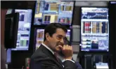  ?? RICHARD DREW — THE ASSOCIATED PRESS ?? Trader Mark Muller works on the floor of the New York Stock Exchange on Thursday. Stocks went into a steep slide after Apple said iPhone sales in China are falling.