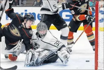  ?? Alex Gallardo Associated Press ?? THE PUCK gets behind Kings goalie Jonathan Quick after a shot by the Ducks’ Adam Henrique, left, during the second period, but it doesn’t reach the net. Quick made 29 saves, giving up two goals.