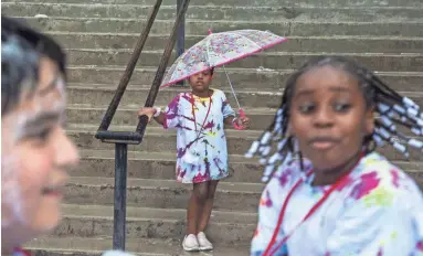  ?? NICK OZA/THE REPUBLIC ?? Malaya Robinson uses an umbrella in the rain outside Phoenix Children Museum on Wednesday.