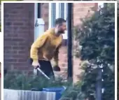  ?? ?? 2 Man dressed in yellow hoodie wielding sword is seen crouching in front garden outside 25 Laing Close