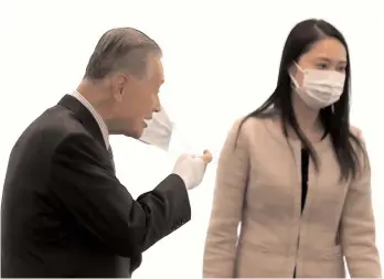  ?? AFP ?? Tokyo 2020 president Yoshiro Mori (left) takes off his face mask as he arrives to take part in a meeting to establish an Olympic Games planning task force in Tokyo on Thursday, two days after the historic decision to postpone the 2020 Tokyo Olympic Games. —