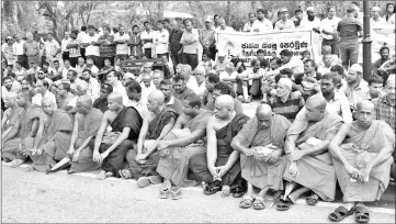  ?? — AFP photo ?? Members of the People’s Liberation Front group and Buddhist monks sit at a roadside as they hold a rally calling for calm following deadly communal violence in other parts of the country, in Sri Lanka’s capital Colombo.