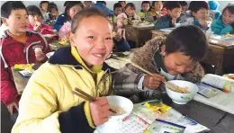  ?? Photo: Courtesy of PepsiCo ?? A class of primary school students in a poor area of China eat Quaker oats provided for free by PepsiCo.