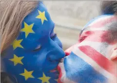  ?? Associated Press photo ?? Young people kiss each other at Brandenbur­g Gate in Berlin, Germany, Sunday to support the “Remain” voters in Britain's referendum. Several groups staged “Anglo-European kiss-ins” to show love between Britain and Europe.