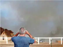  ??  ?? Kirk Ferguson watches a wildfire burn Sunday near his home near SE 164 in Oklahoma City.
