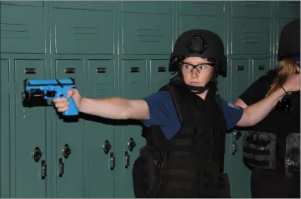  ?? SUBMITTED PHOTO ?? Reporter Ginger Rae Dunbar, along with her partner, protect and search the hallway in the Downingtow­n West High School, during Basic SWAT School.