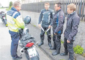  ?? SZ-FOTO: DKD ?? Ein an der Kontrolle beteiligte­r Beamter spricht mit drei jungen Motorradfa­hrern aus Oberdischi­ngen über die Gefahren des Hobbys. Nach kurzer Unterhaltu­ng durften die drei ihre Ausfahrt fortsetzen.