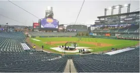  ?? AP PHOTO/DAVID ZALUBOWSKI ?? Players take part in batting practice as a light rain descends Tuesday on Coors Field before the Colorado Rockies host the Arizona Diamondbac­ks.